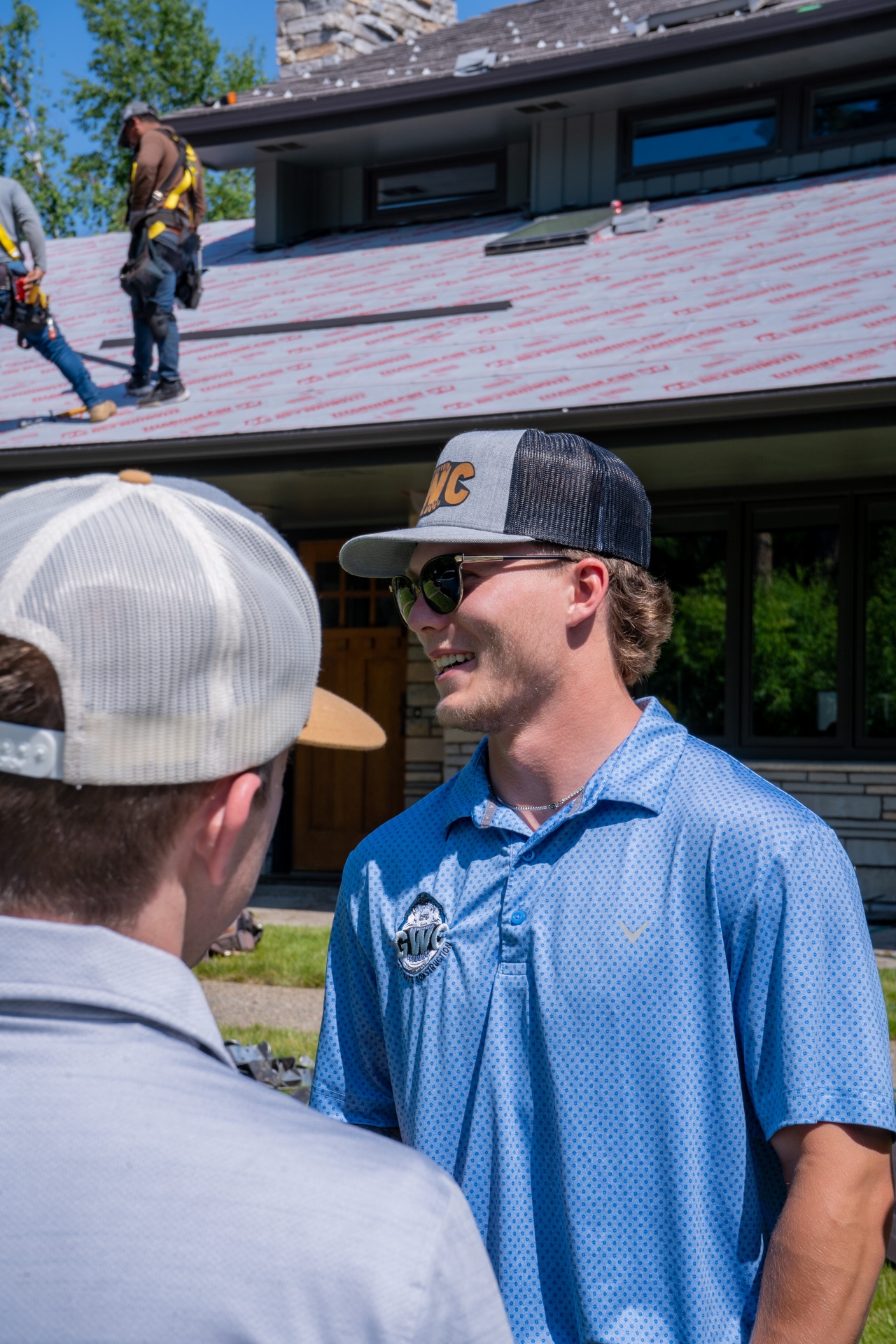 Great White Construction advisor speaking with a homeowner at an active roofing project